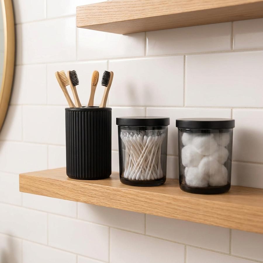 Matte black toothbrush holder and qtip holders on bathroom shelf